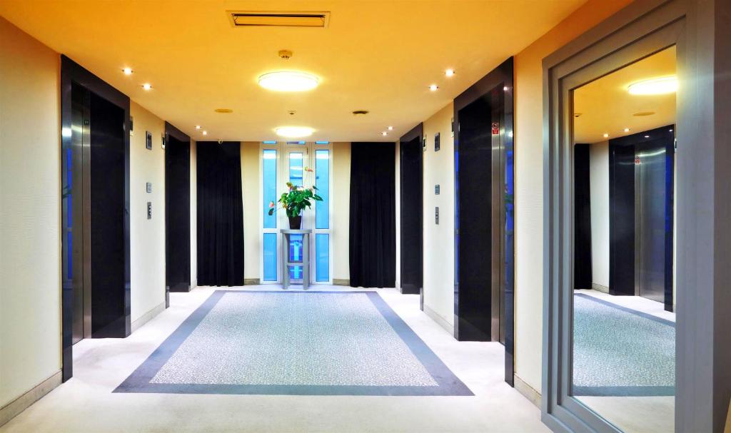 a hallway of an office building with a plant on a table at Don Giovanni Hotel Prague - Great Hotels of The World in Prague