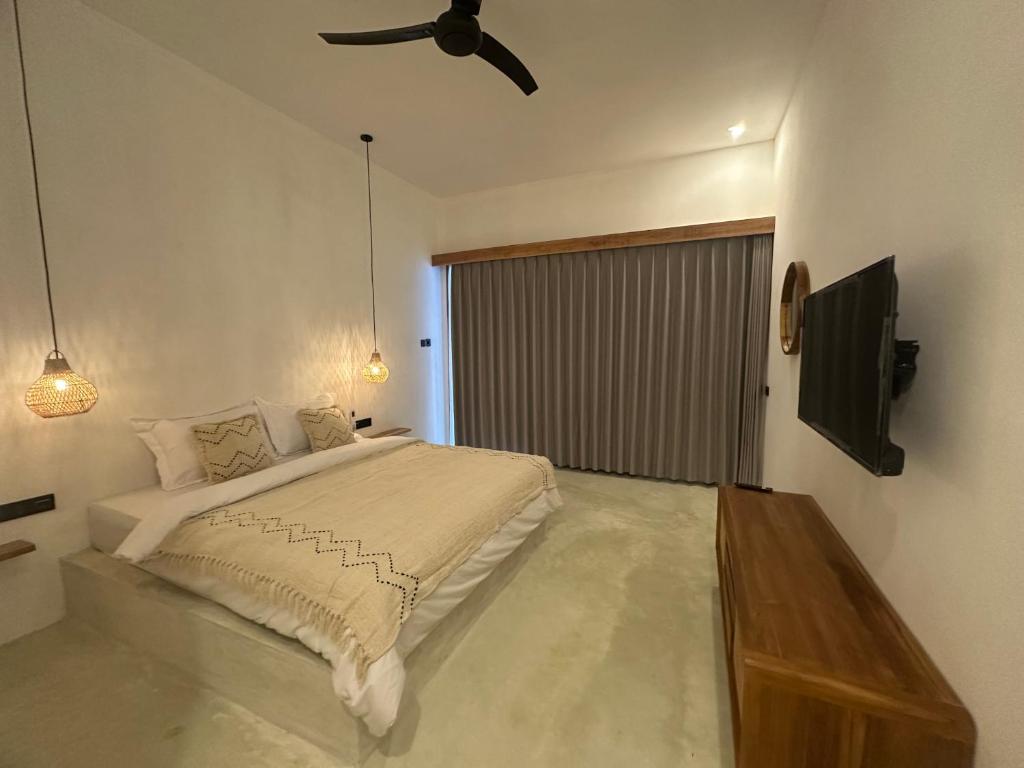 Un dormitorio con una cama y un ventilador de techo. en Radin Group 8, en Kuta Lombok