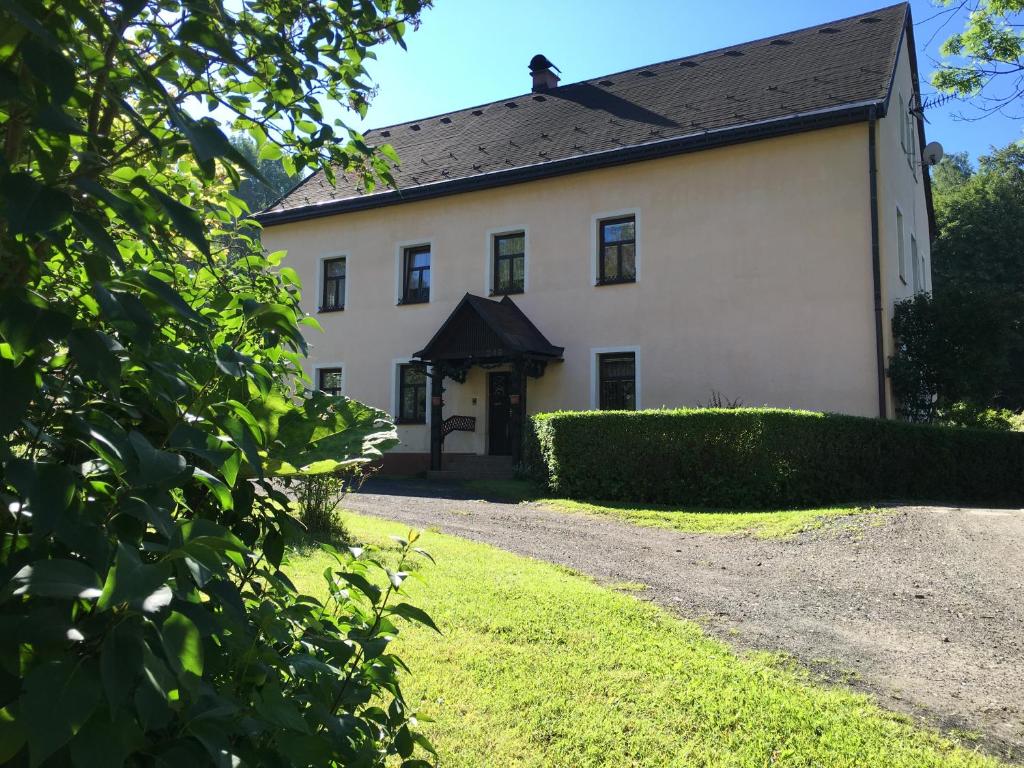 a large white house with a gravel driveway at U Evy Jarošové in Desná