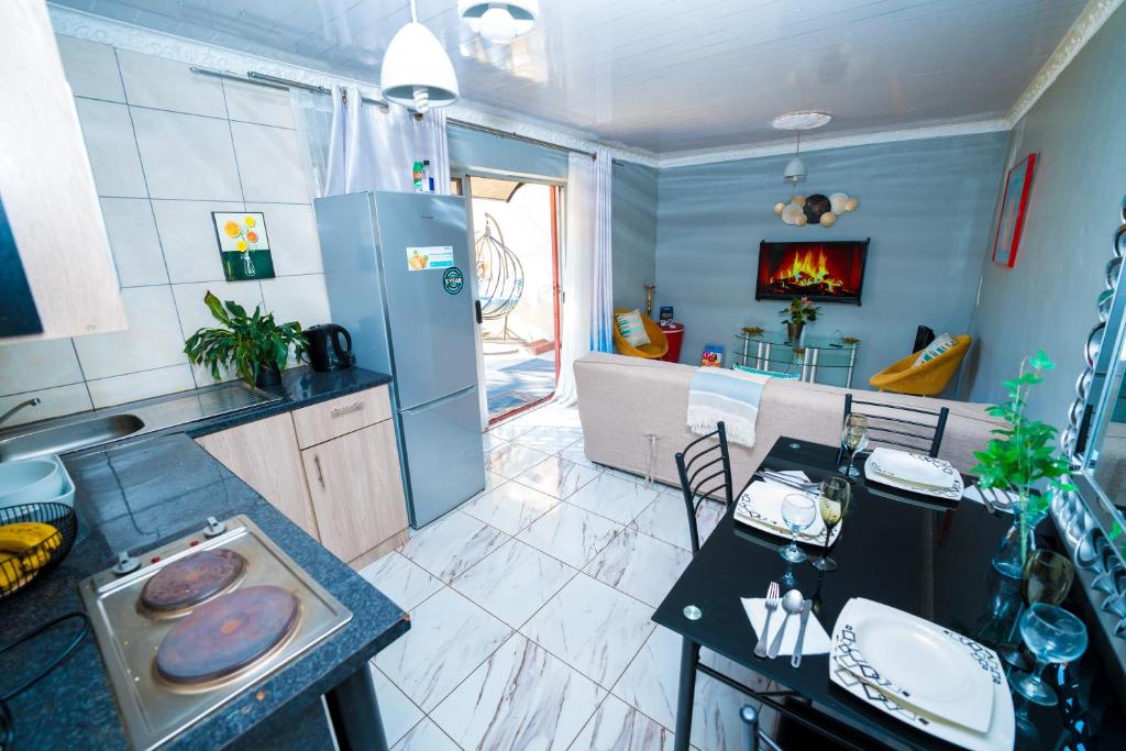 a kitchen with a refrigerator and a table with donuts on it at Terry’s Cozy cottage in Germiston
