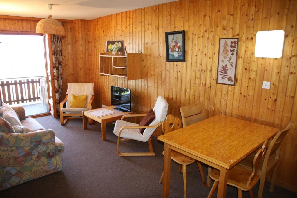 a living room with a table and a wooden wall at Iris I 031 - CONFORTABLE apartment 6 pers in Veysonnaz