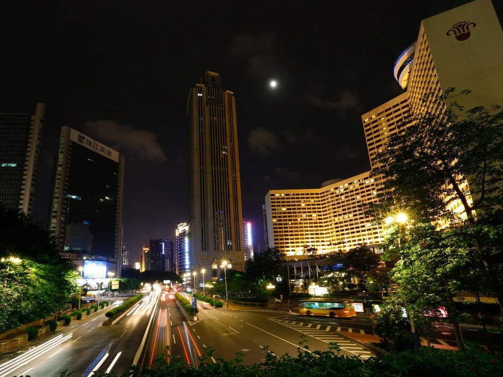 una calle de la ciudad por la noche con edificios y coches en Guangzhou Boman Apartment Zhengjia Huanshi Branch en Guangzhou