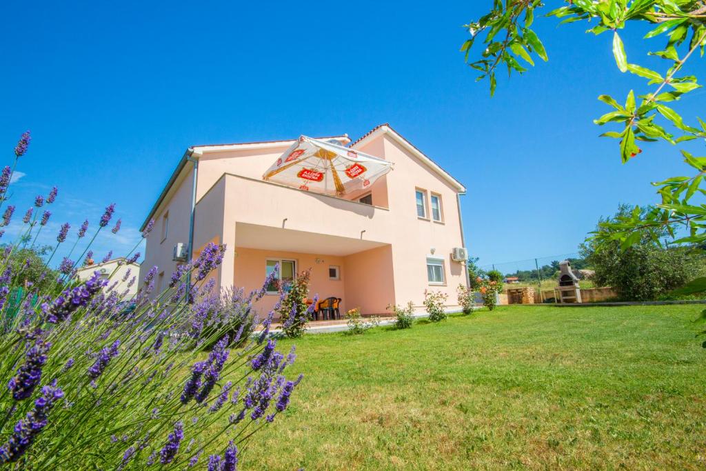 a house in a field with purple flowers at Pula Istria Apartments in Pula