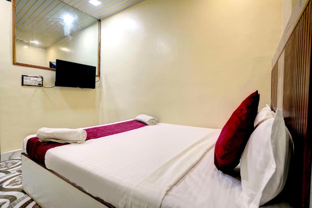 a bed with red pillows in a room at Hotel Akasa View in Mumbai