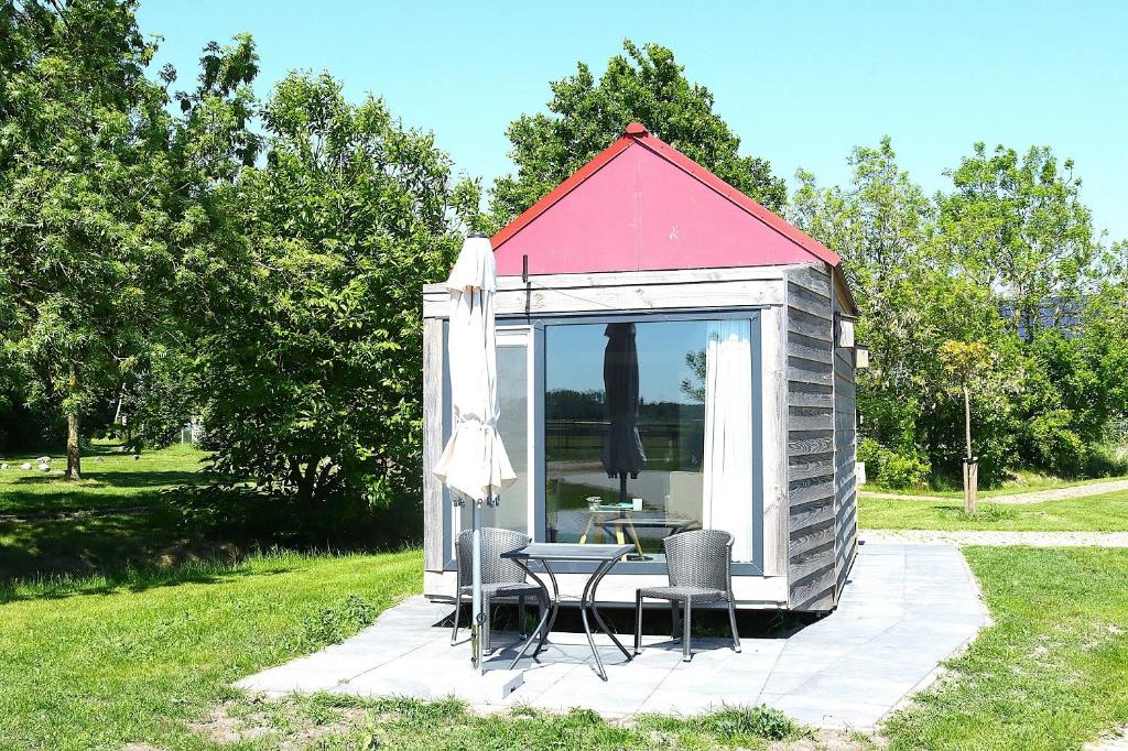 a gazebo with a table and chairs in it at Tiny Cottage op Camping "De stal" in Drijber