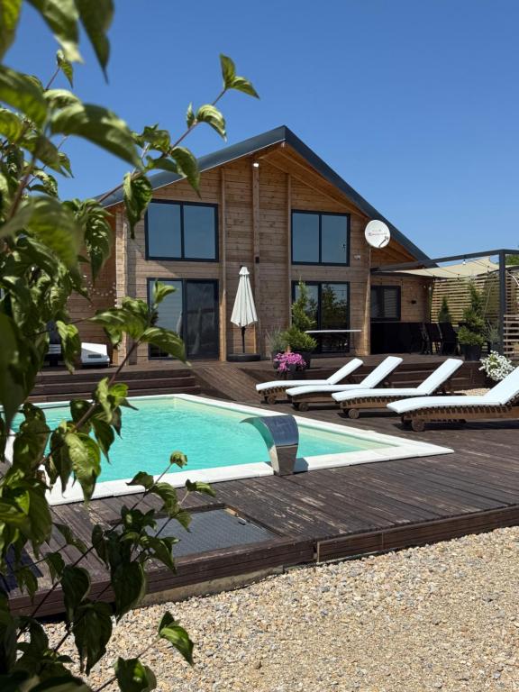 a house with a swimming pool and a wooden deck at Casa del Corniolo Spa and Pool House Fruška gora in Čortanovci
