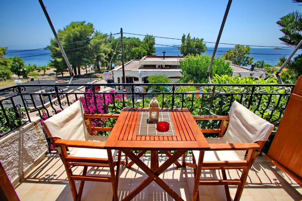 a table and chairs on a balcony with a view of the ocean at Studios and Apartments Meri in Neo Klima