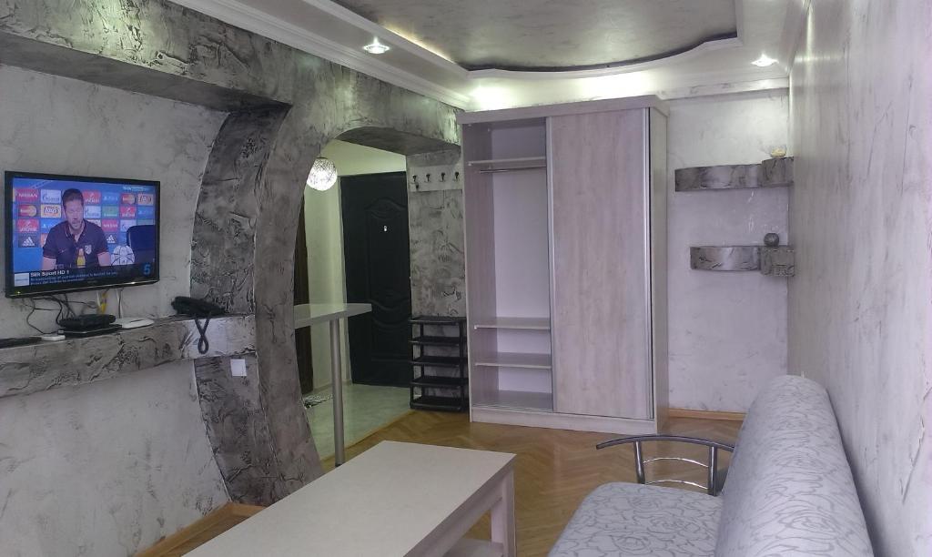 a living room with a tv on a stone wall at Irakli's Apartment with Sea view in Batumi