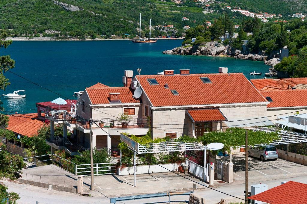 ein Haus mit roten Dächern neben einem Wasserkörper in der Unterkunft Villa Ana in Zaton