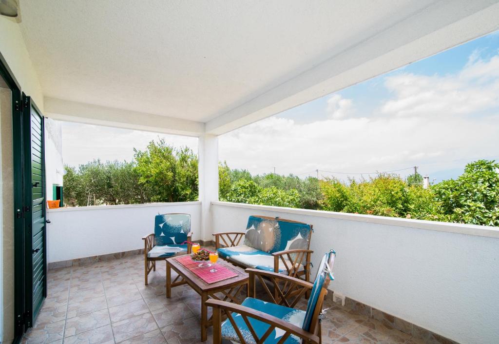 a balcony with chairs and a table and a table at Apartments Cafe del Mar in Supetar