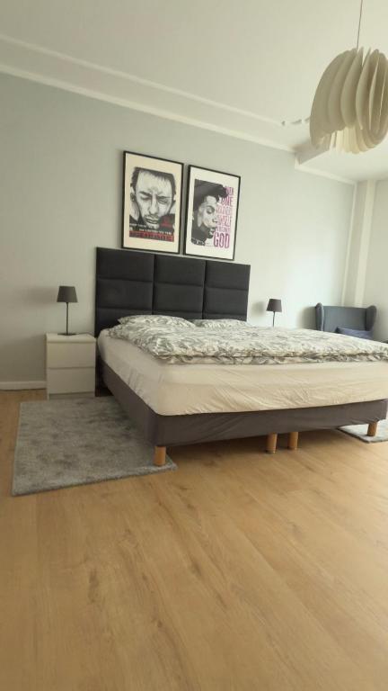 a bedroom with a bed and three pictures on the wall at Wunderschönes Single Apartment in Berlin