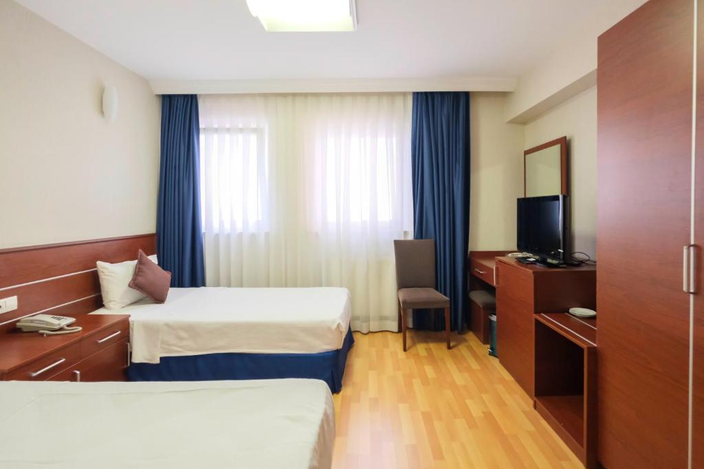 une chambre d'hôtel avec deux lits et une télévision dans l'établissement Siyav Otel, à Ankara