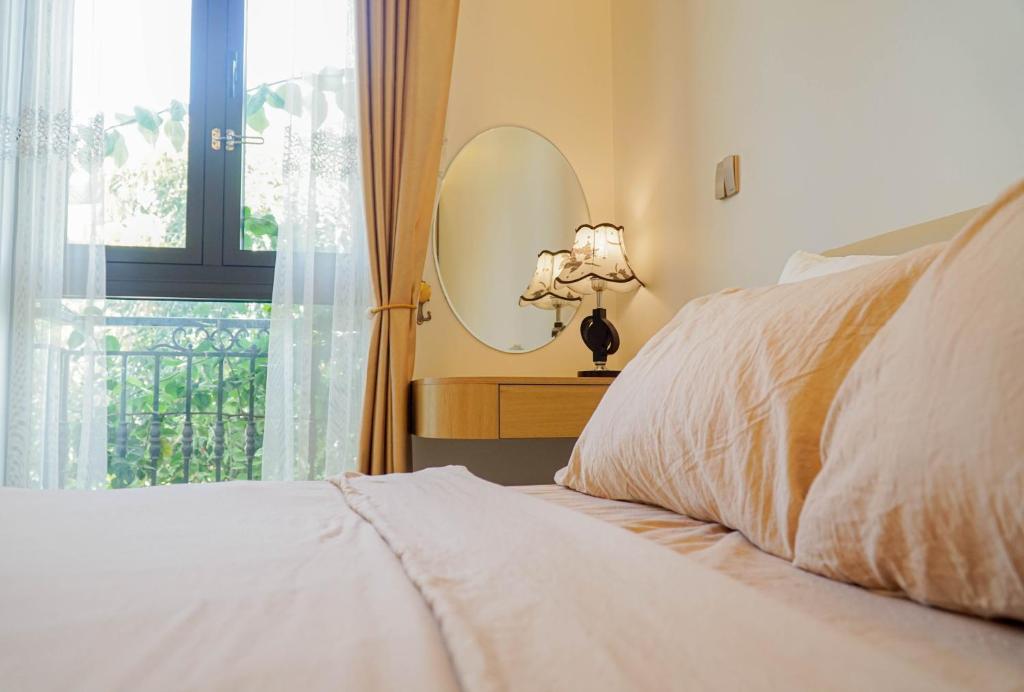 ハノイにあるTH Villa, Vinhome Ocean Park, Hanoiのベッドルーム1室(鏡付きのベッド1台、窓付)