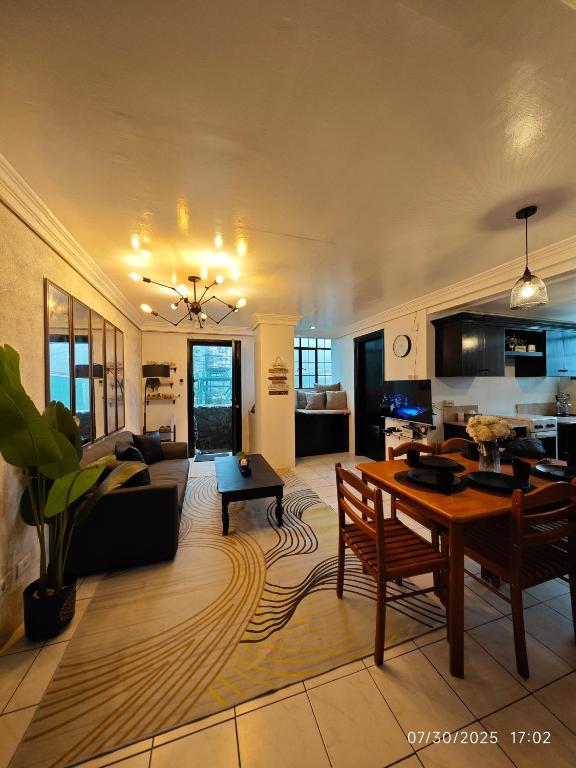 un soggiorno con un tavolo e un divano di Luxhomme Baguio Guest Homestay with Balcony a Baguio