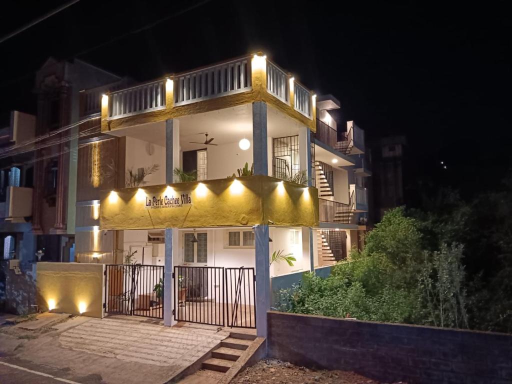 a white building with lights on it at night at La Perle Cachee Villa in Kuilapayam
