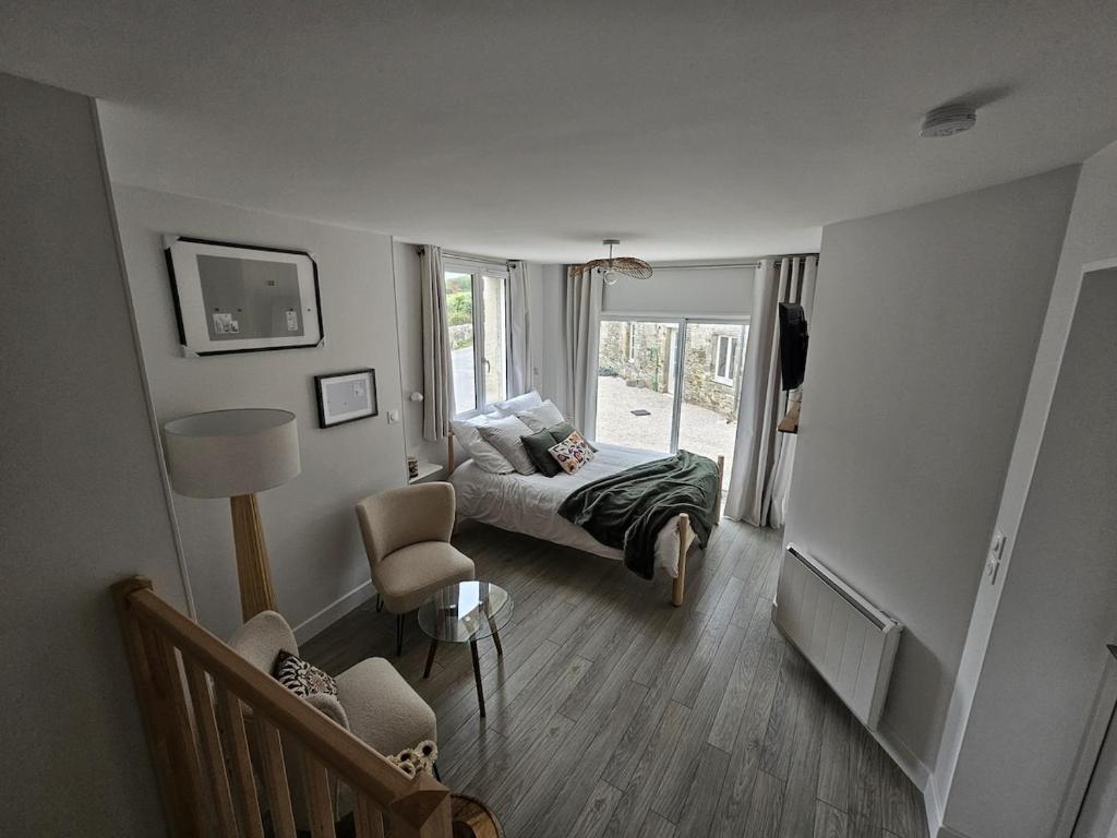 a living room with a couch and a bed and a window at Studio indépendant Le Vast in Le Vast