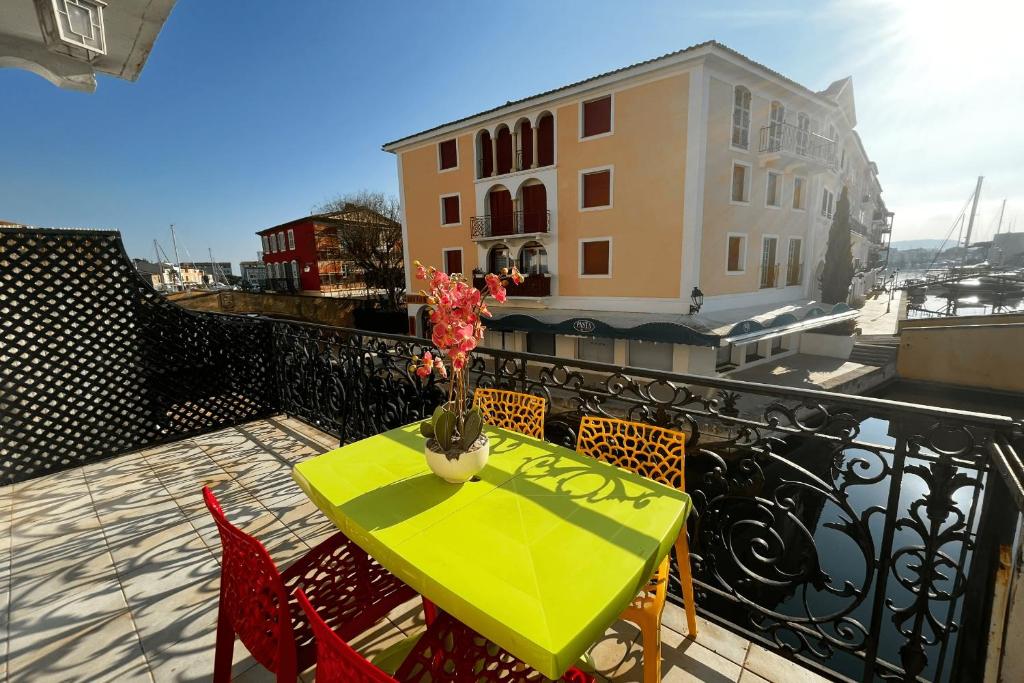 d'une table et de chaises vertes sur un balcon dans l'établissement Bright duplex in the heart of Port Grimaud 1, à Grimaud