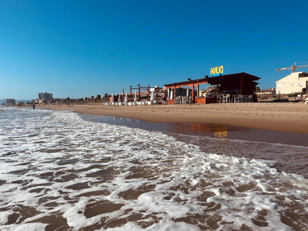 a sandy beach with footprints in the water at Duna Sunset - Ganador Traveller Awards 2026 in Daimuz