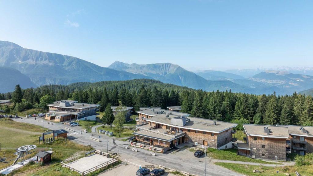 une vue aérienne sur un bâtiment avec des montagnes en arrière-plan dans l'établissement V du Bachat Arolles A n26 - 2P4, à Chamrousse