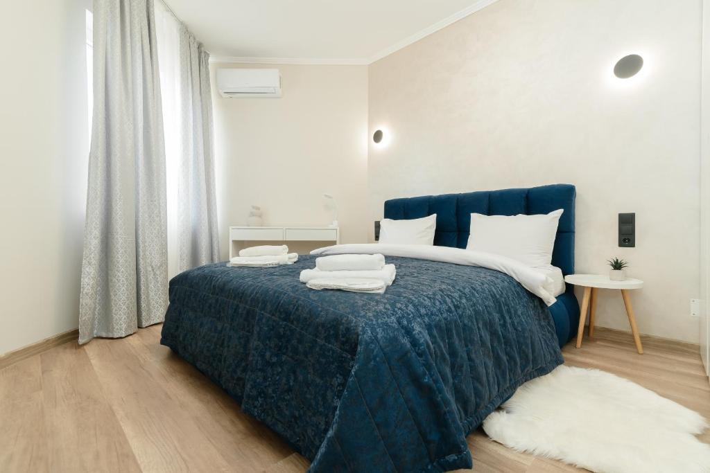 a bedroom with a blue bed with towels on it at ERA RENT Apartments in Chişinău