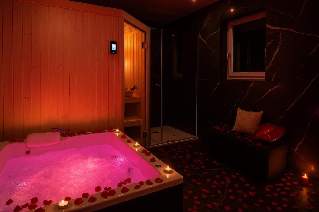a bathroom with a pink tub with lights in it at Love Room Royan in Royan