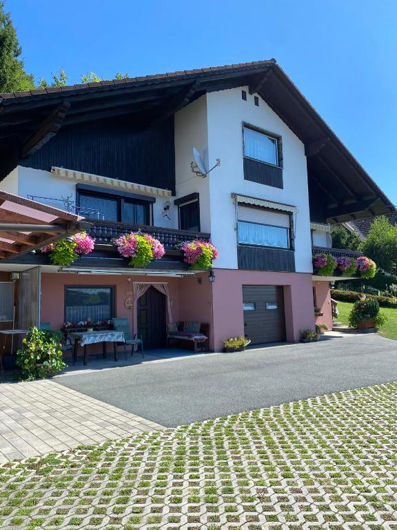 a house with flowers on the balconies of it at Ferienwohnung Zapfl Maria in Greisdorf