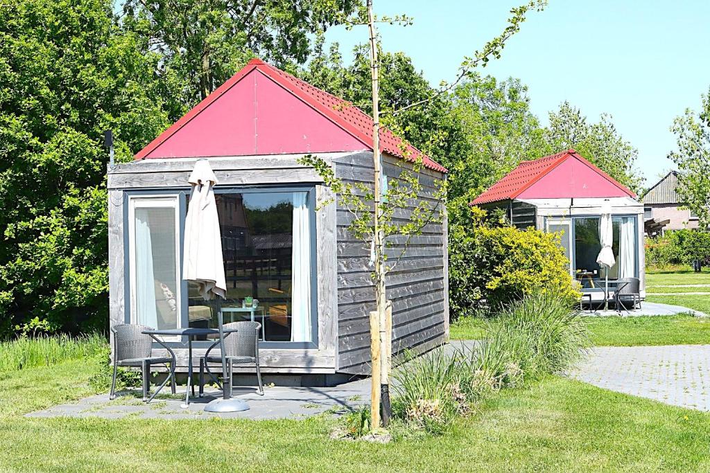 eine kleine Hütte mit Tisch und Stühlen in einem Hof in der Unterkunft Tiny Cottage 2 in Drijber