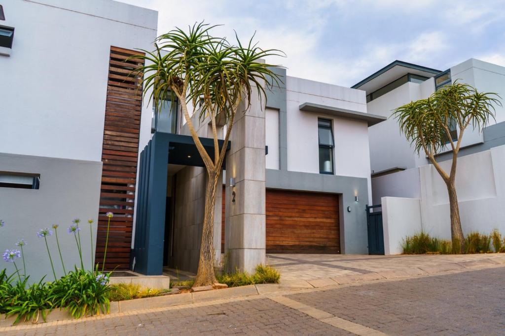 a house with palm trees in front of it at Cosy Corner Sandton in Vosburg