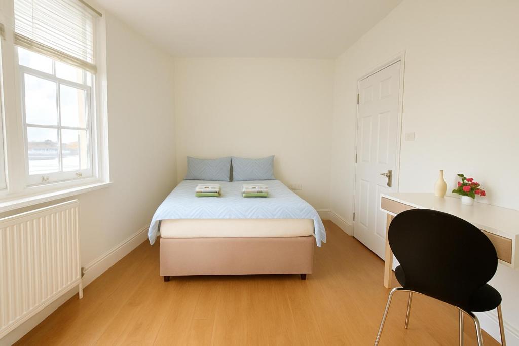 a bedroom with a bed and a desk and a chair at Central Guest Studio - En-Suite - Vibrant London in London