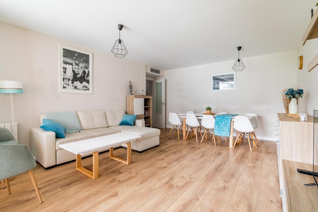 Una sala de estar con un sofá, una mesa y sillas. en Apartamento Dulcinea, en Alcalá de Henares