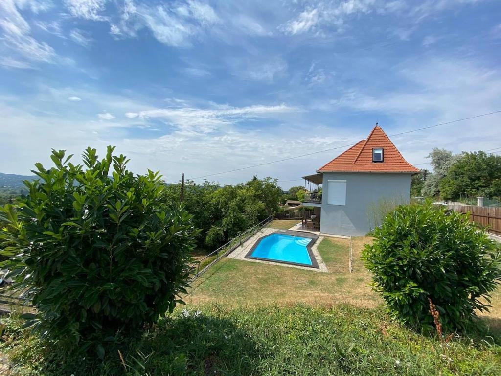 una piccola piscina accanto a una piccola casa di Ravenswood Cottage a Balatonfůzfő