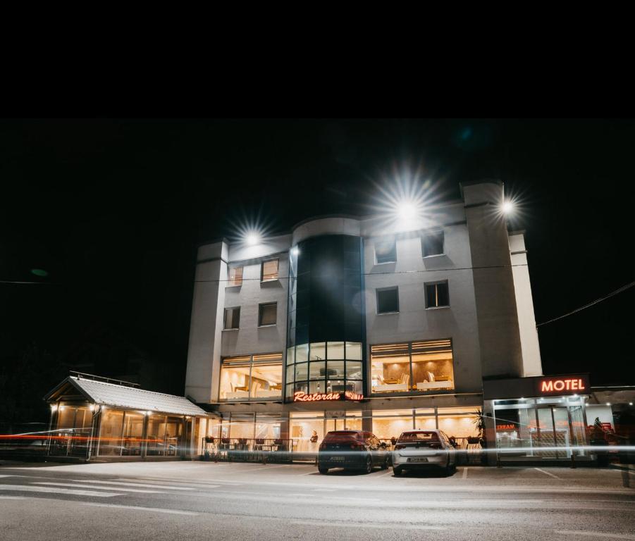 a building with two cars parked in front of it at Mostarlic Motel in Raskršće