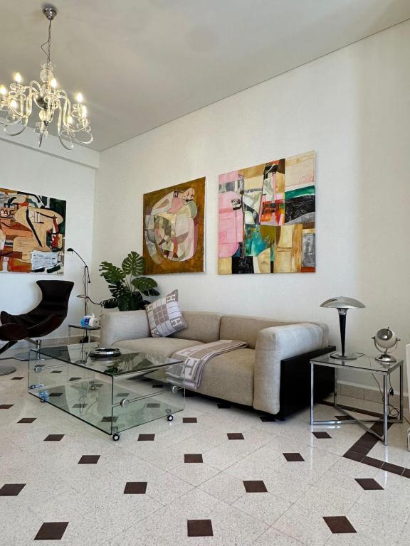 Una sala de estar con un sofá y una mesa de cristal. en Maison Lumiere 2-BD, en Beirut