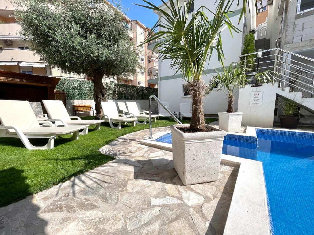 a courtyard with lounge chairs and a swimming pool at Apartments Pribilovic in Budva