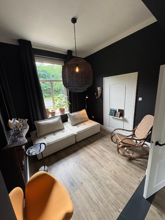 a living room with a couch and a window at Maastrichtse buitenwoning in Cadier en Keer