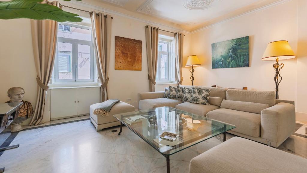 ein Wohnzimmer mit Sofa und Tisch in der Unterkunft Garden Mansion in Historic Center by LovelyStay in Lissabon