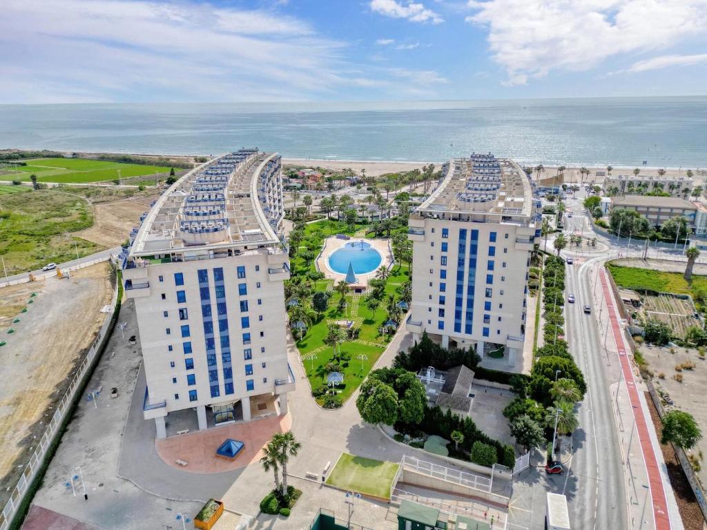 an overhead view of two buildings with the ocean in the background at Beachfront Family Appartment with Pool in Valencia