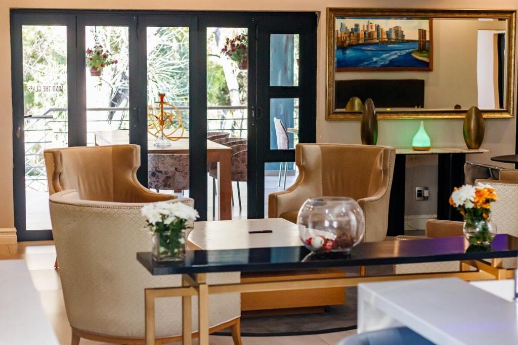 a living room with a table and chairs at Braham Lodge - The Octave 5 in Johannesburg