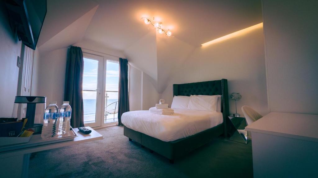a bedroom with a bed and a large window at The Feather's Hotel Newquay in Newquay