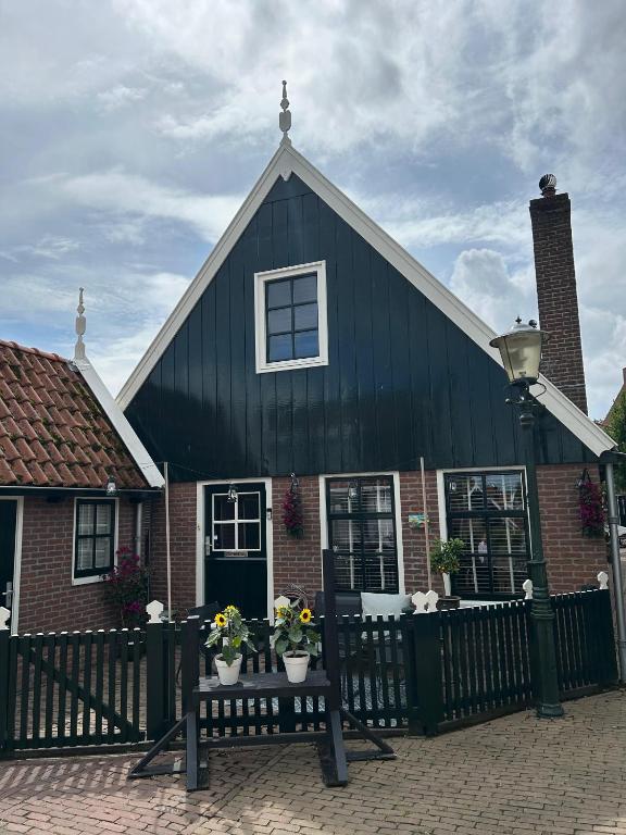 a black house with a bench in front of it at Urker Ussien in Urk