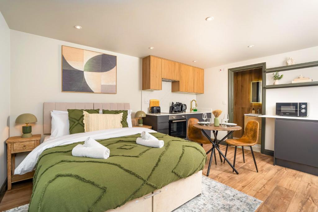 a bedroom with a large bed and a kitchen at Chic Studio Easy City Links Perfect Stay Wifi & Parking in New Southgate