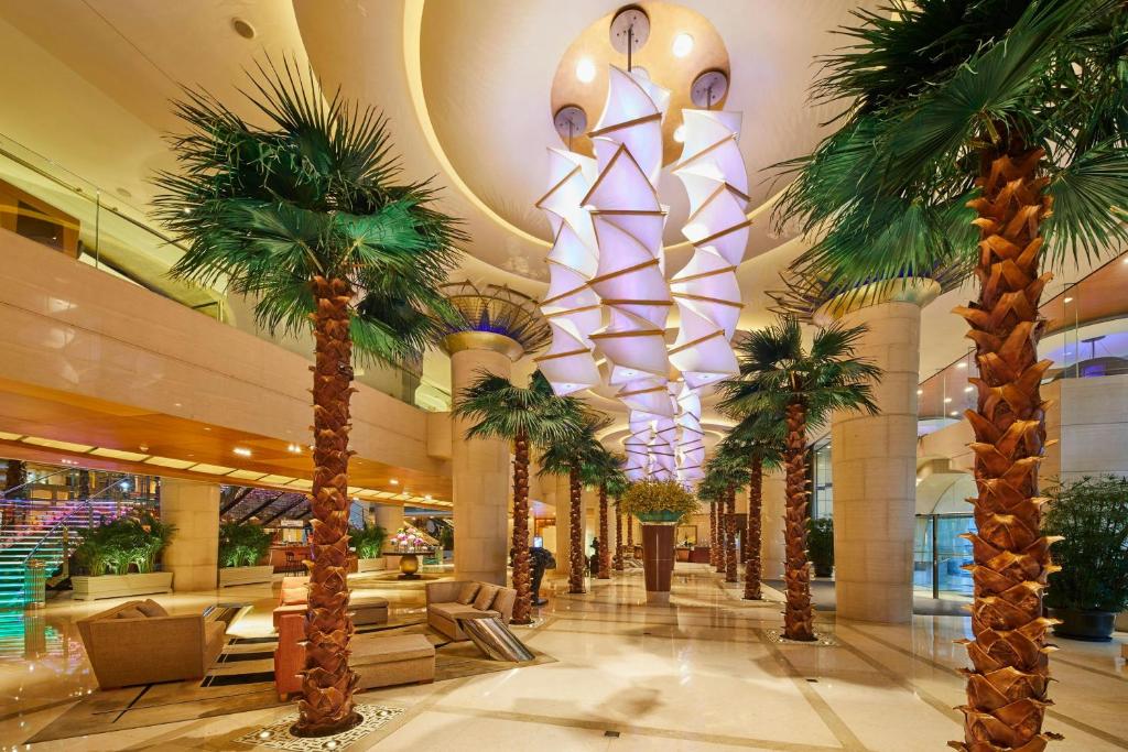 a lobby with palm trees in a mall at The Westin Bund Center, Shanghai in Shanghai