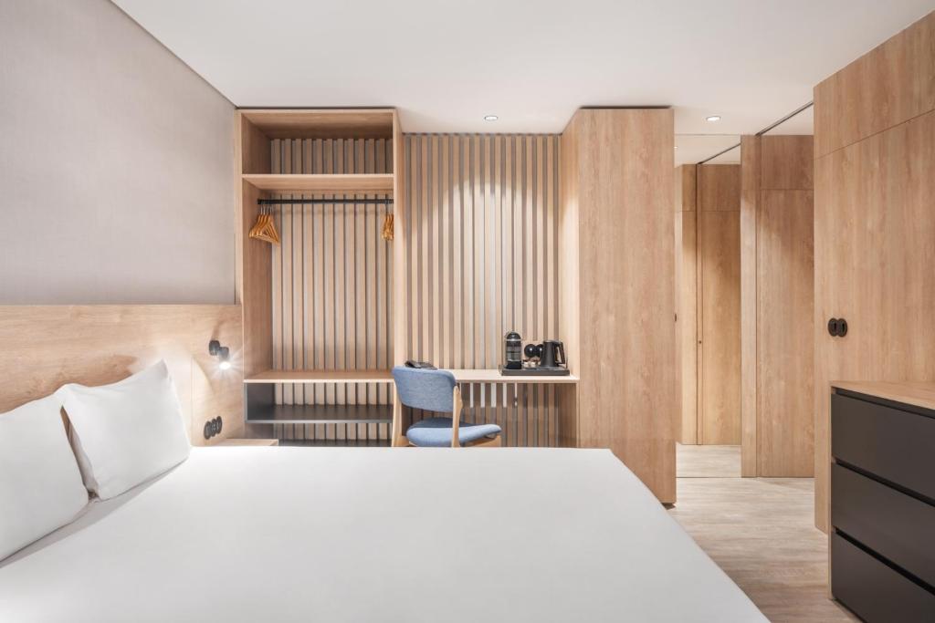 a bedroom with a white bed and a desk at Moov Apartments Boavista in Porto