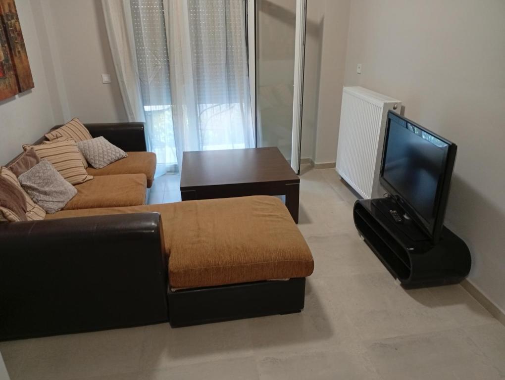 a living room with a couch and a flat screen tv at Central apartment's in Trikala 2 in Tríkala