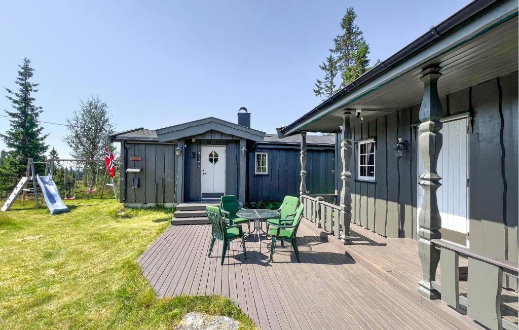 Una terraza con sillas y una mesa frente a una casa. en Beautiful Home In Sjusjøen With Sauna, en Sjusjøen
