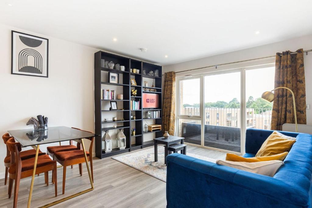 ヘンドンにあるGuestReady - Millbrook Park retreat with balconyの青いソファとテーブルのあるリビングルーム