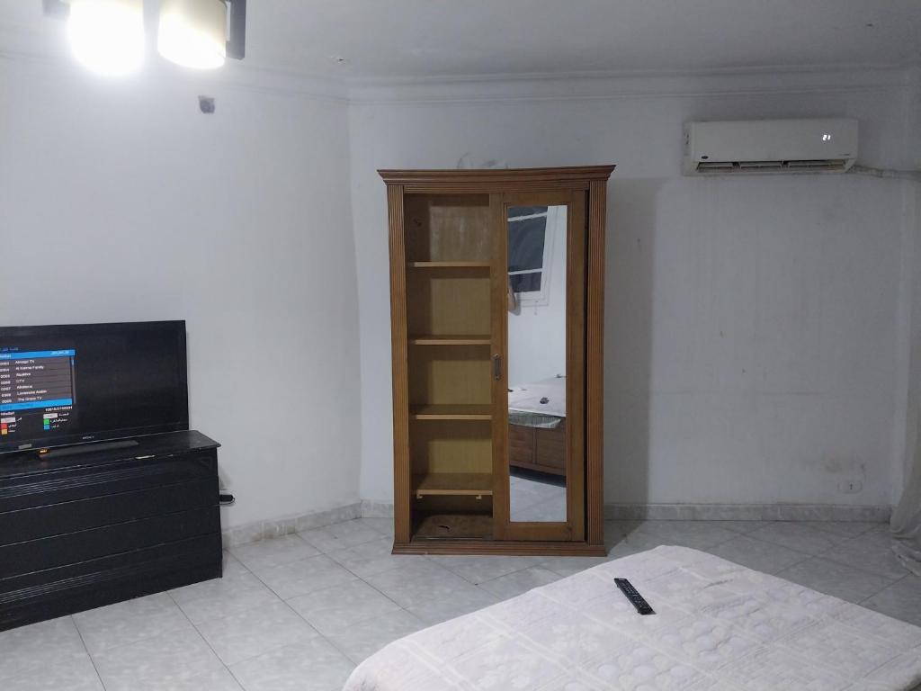 a room with a room with a television and a closet at Female privat rooms cairo center in Cairo