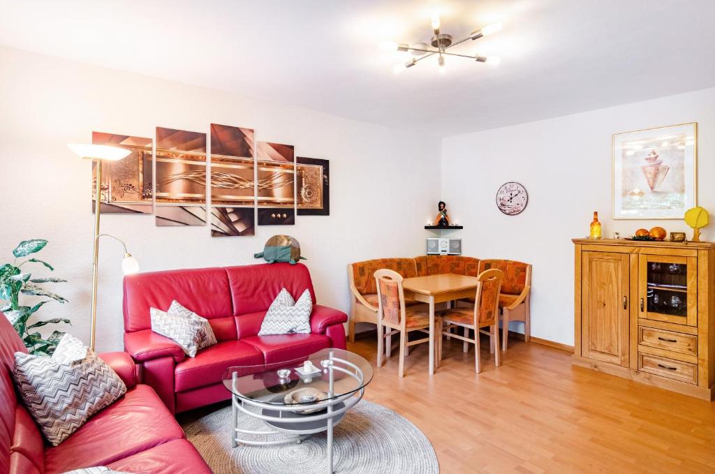 un salon avec un canapé rouge et une table dans l'établissement Ferienwohnung Schmälzle, à Braunlage