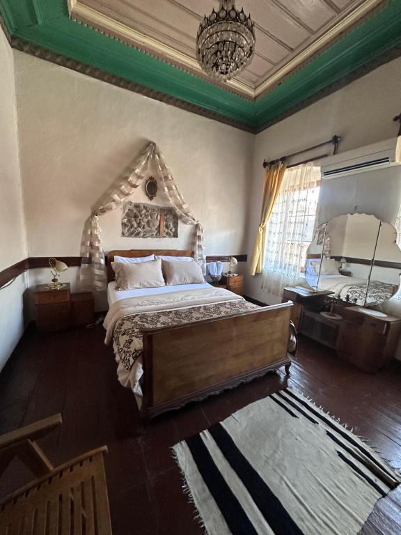 ein Schlafzimmer mit einem großen Bett und einem Kronleuchter in der Unterkunft Pergamonpension in Bergama