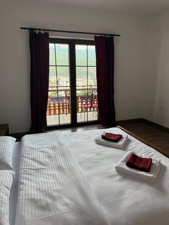 a bedroom with a white bed with two towels on it at Robinson Sunrise House Old town in Ohrid